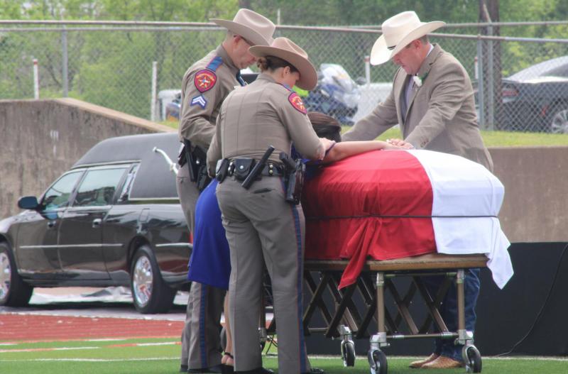 DPS troopers and Pastor Jimmy Cotton console Tobie Walker, widow of slain Trooper Chad Walker, at the end of his funeral at Groesbeck High School’s football stadium Thursday, April 6. Jennifer Paul/Groesbeck Journal Put on the full armor of God