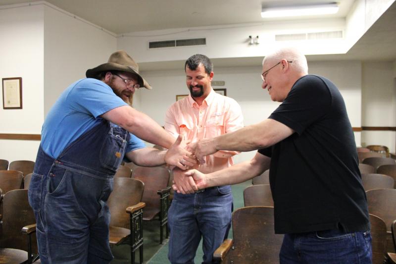 As early voting totals roll into the County courtroom on Tuesday, March 5, Quest Bates, Kendall Funderburk, and Doug Potts shake hands to wish good luck and camaraderie.