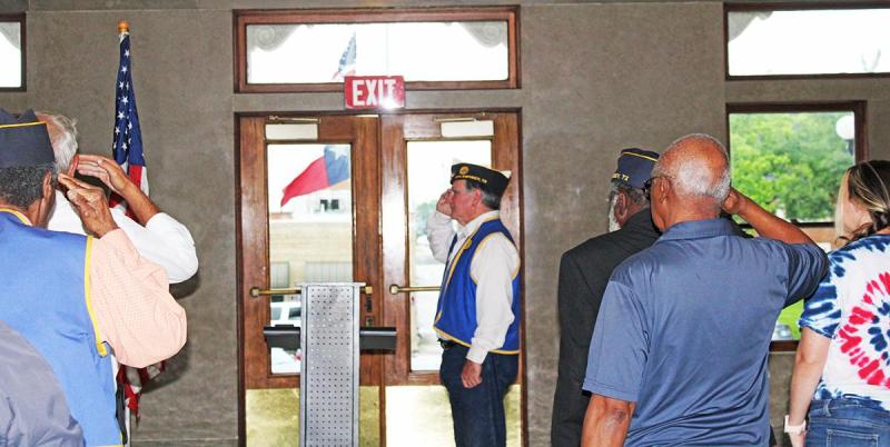Post Commander Russ Foster and members of the community salute the American Flag during the National Anthem and Plege of Allegiance on Monday, May 26 at the Memorical Day Ceremony at Limestone County Courthouse. 