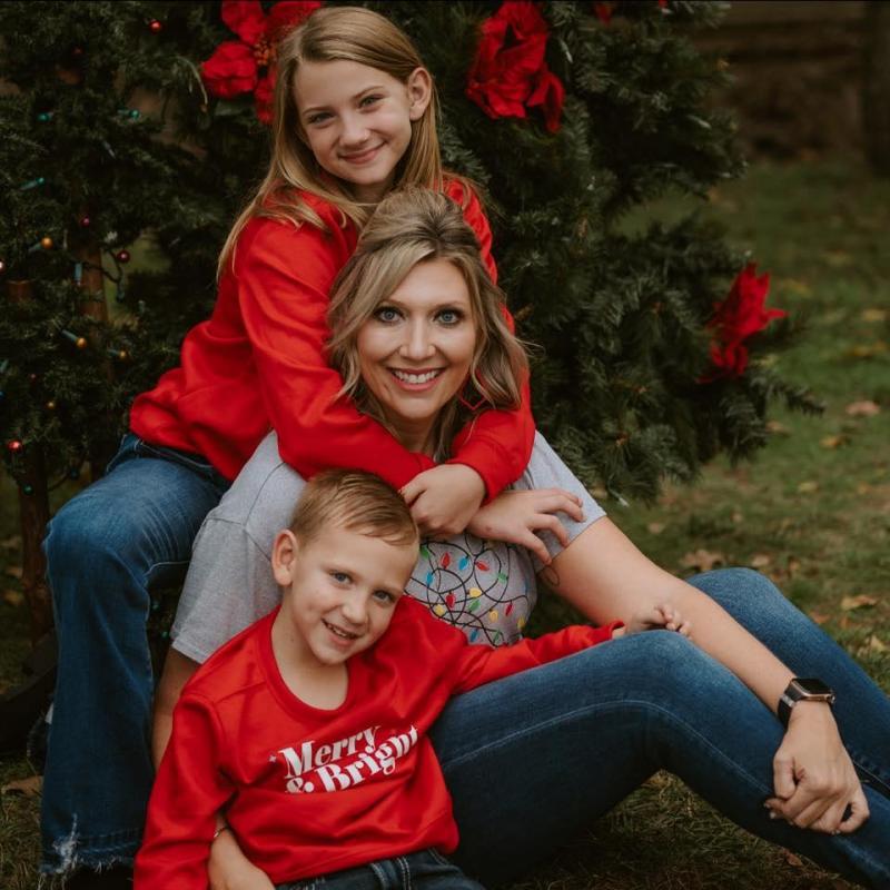 Krystal Swinnea and her children, 10-year-old Laramie and 5-year-old Hudson, pose for Christmas photos in 2023. Article Image Alt Text