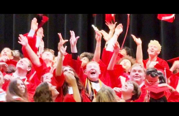 Tanner Sanders throws his cap in the air along with his classmates at the end of graduation. Photo Submitted by Melissa Dukes Sanders