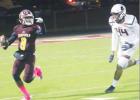 ABOVE: Fairfield quarterback Justin Abram (8) directs a receiver downfield as he is chased by Mexia defensive end Dawson Scott (44) during a game at Fairfield on Friday night. ’Cats take advantage of Eagle miscues for win