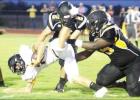 ABOVE: Coolidge’s Roderick Busby (right) and Cole Kutscherousky (2) combine to bring down a Jonesboro runner during a six-man football game at Coolidge on Friday night. Article Image Alt Text