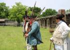 (l-r) Jeff Kirkman, Reed Kirkman, and Tom Boltz stand at attention preparing to fire a powder-only rifle shot as a demonstration at the 18th century Living History demonstration at Old Fort Parker Saturday, May 11. Article Image Alt Text