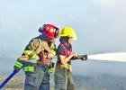 Lake Mexia VFD firefighters John Dabney, left, and Nick Martinez work together to fight a blaze on a burning 18-wheeler in February 2017 at what was then the Tippie Ranch. Dabney is now fire chief at the MSSLC Volunteer Fire Department. Contributed Photo