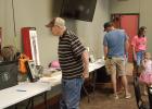 Community members slowly walk the outer edge of the room taking in all 63 items available for the silent auction. Article Image Alt Text