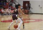 Groesbeck guard Makayla Banks throws a pass around 6-foot-1 McKinna Brackens of Fairfield (21) during a game at the Groesbeck High School gym Tuesday night. Fairfield, the No. 1 team in the state, rolled to an 83-16 win.  Photo by Skip Leon/The Groesbeck Journal